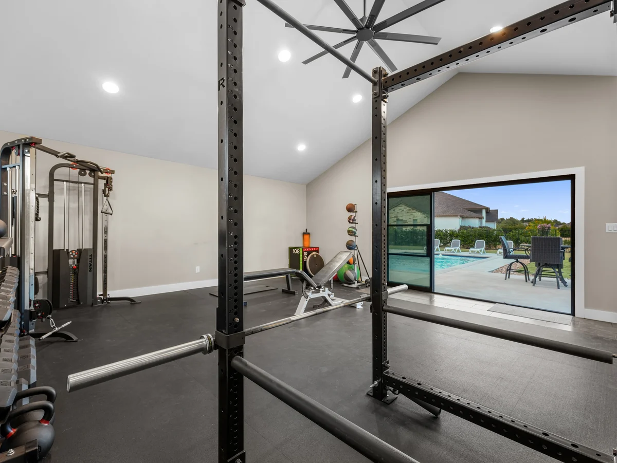 Interior of the detached casita, currently arranged as a gym, with sliding doors opening to the pool